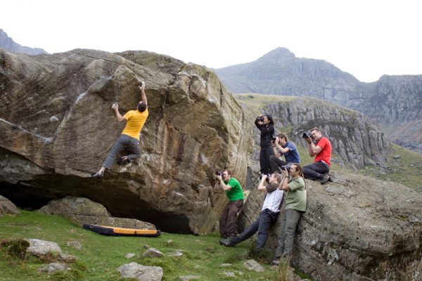 Climber on rock face being photographed by students on a workshop