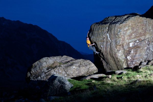 Night time shot of climbing going up rock face